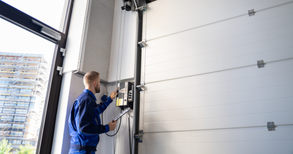 Worker adjusts garage door.