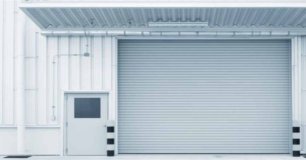 Closed grey industrial garage door exterior.